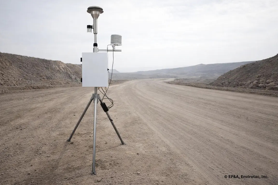Field particulate monitor measuring PM10 and PM2.5 levels beside an unpaved industrial haul road under real conditions.